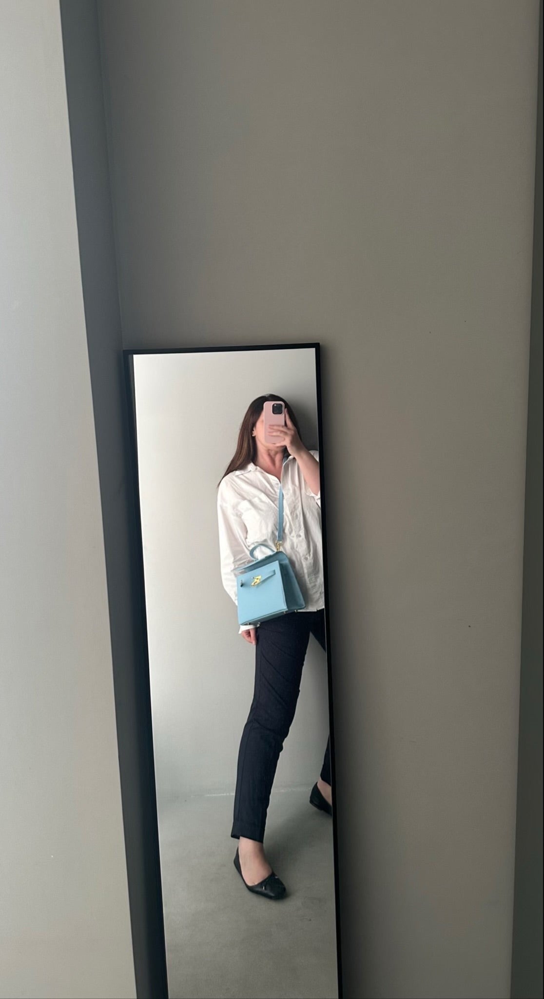 Lala Collection light blue faux leather handbag with gold hardware and removable strap worn by a woman in a mirror.